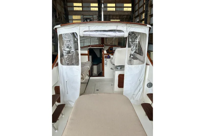 Stardust Yacht Photos Pics 1996 Hinckley Picnic Boat interior with white canopy and wooden accents in a storage facility.