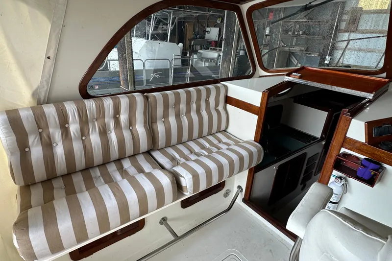 Stardust Yacht Photos Pics Interior of a 1996 Hinckley Picnic Boat with striped seating and wooden accents.