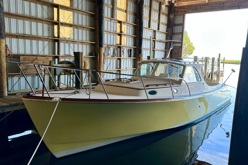Stardust Yacht Photos Pics 1996 Hinckley Picnic Boat docked in a wooden boathouse.