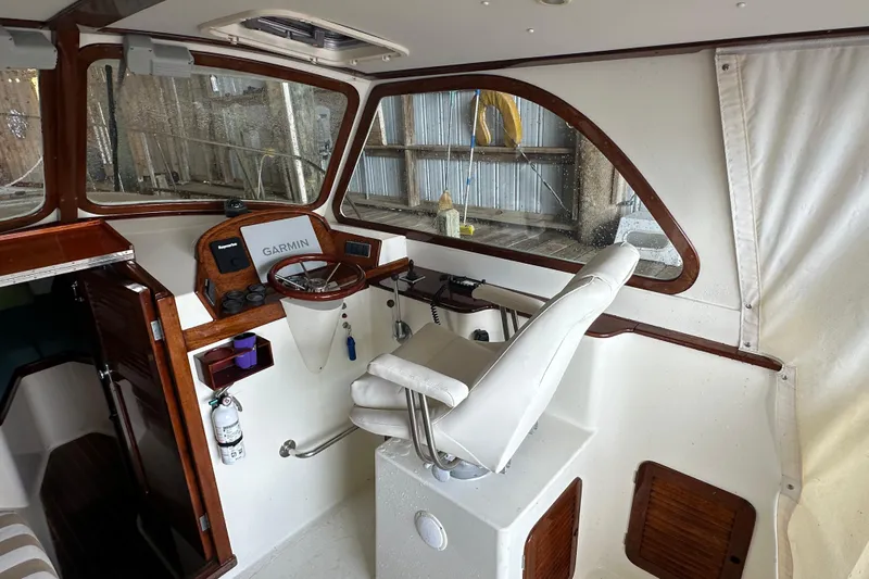 Stardust Yacht Photos Pics 1996 Hinckley Picnic Boat interior with steering wheel, Garmin navigation, and white captain's chair.