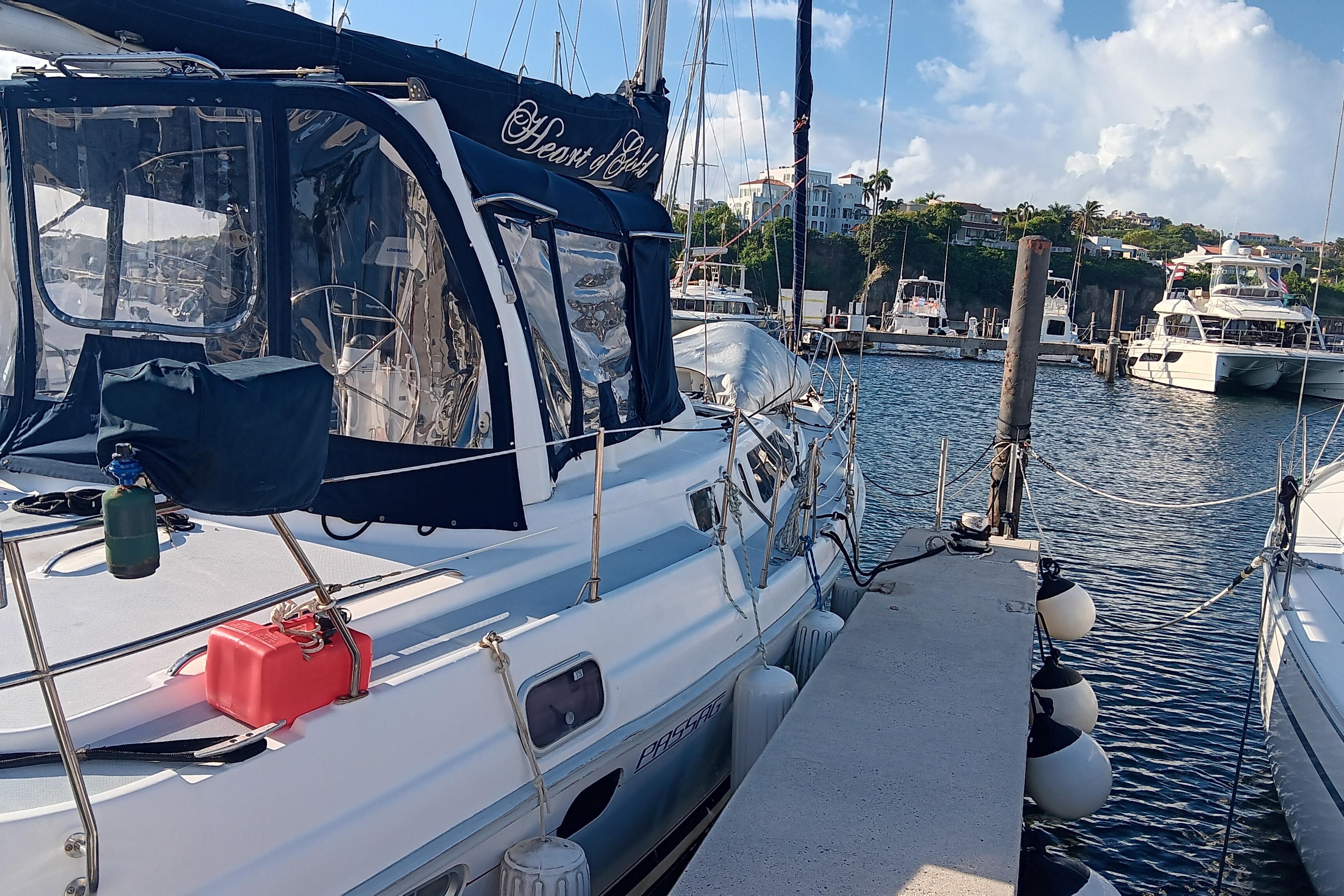 Sailboat docked at marina, 1998 Hunter 450 model, clear skies, calm waters.