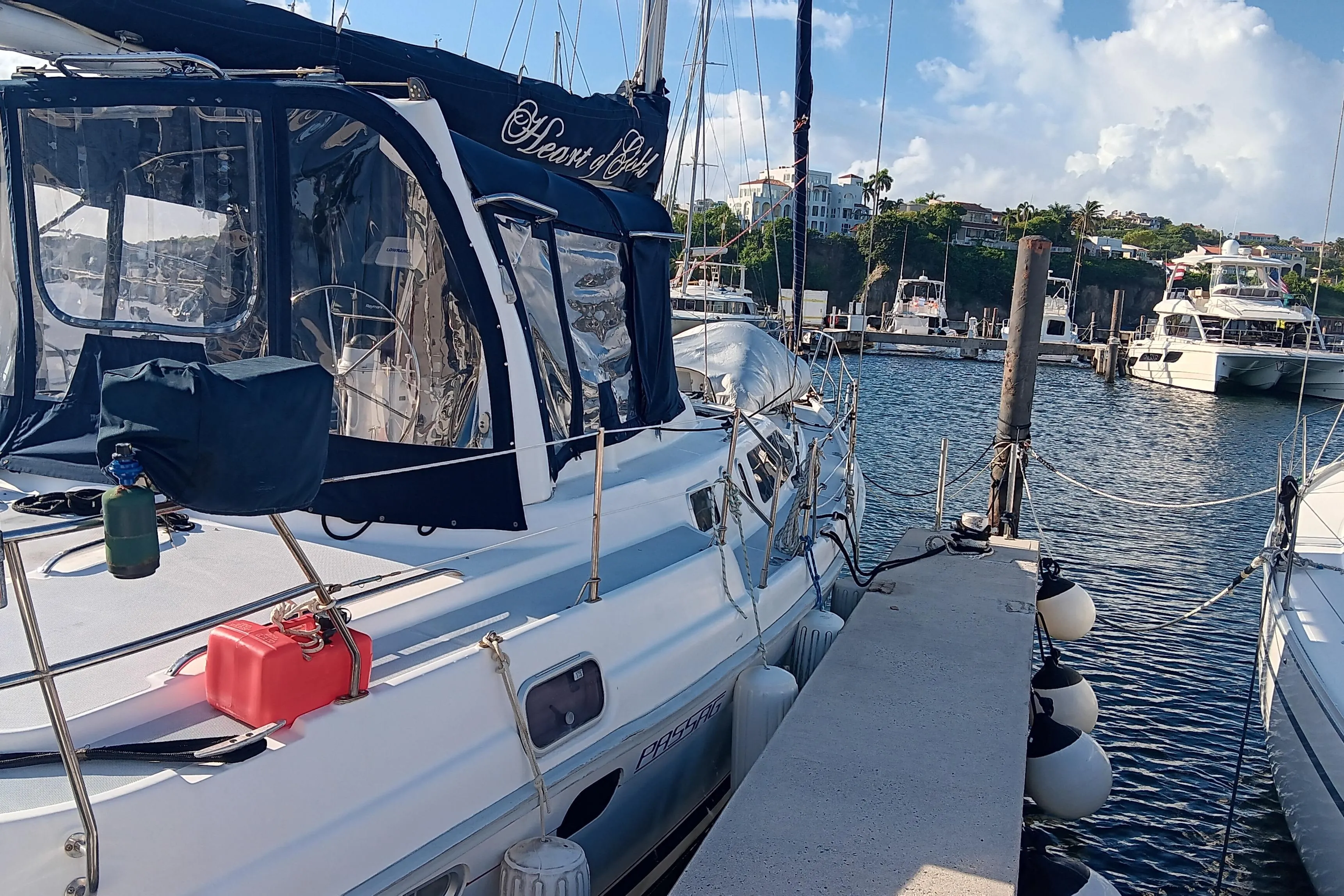 Sailboat docked at marina, 1998 Hunter 450 model, clear skies, calm waters.