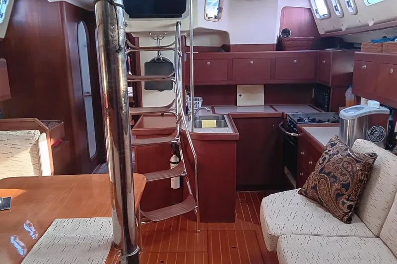 Heart Of Gold Yacht Photos Pics Interior of a 1998 Hunter 450 yacht with wooden cabinetry and cozy seating area.