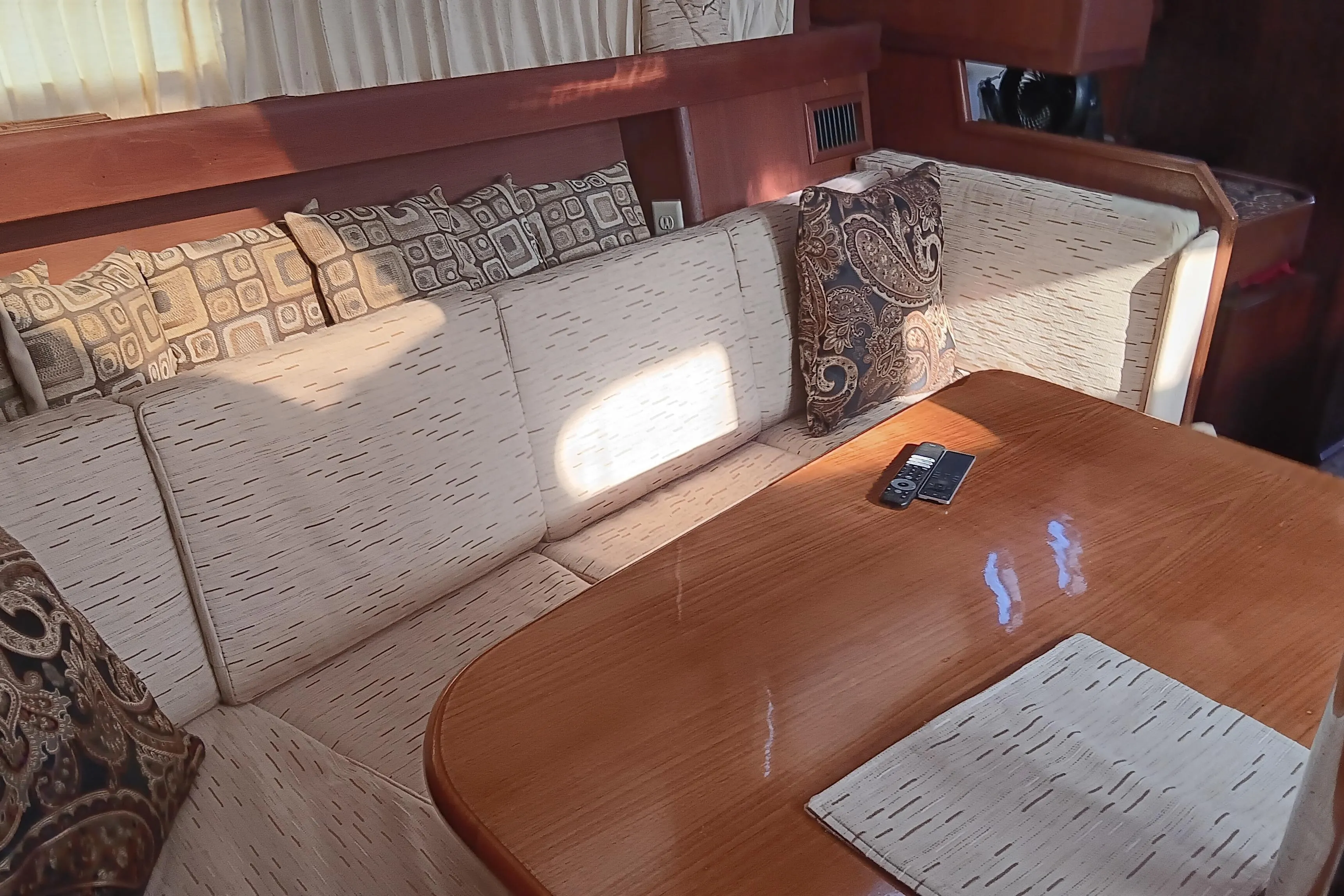 Interior of a 1998 Hunter 450 yacht with cushioned seating and wooden table.