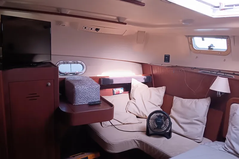 Heart Of Gold Yacht Photos Pics Cozy interior of 1998 Hunter 450 yacht with cushions, fan, and TV.