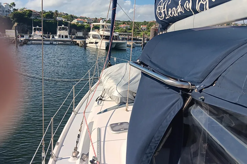 Heart Of Gold Yacht Photos Pics Sailboat docked in marina, Hunter 450 model, 1998, with blue canopy and scenic background.