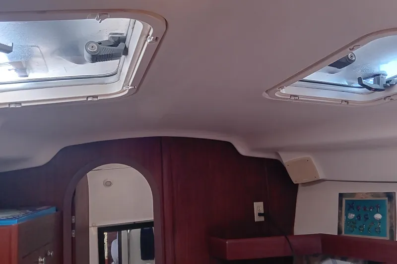 Heart Of Gold Yacht Photos Pics Interior of a 1998 Hunter 450 sailboat showing ceiling hatches and wooden cabinetry.