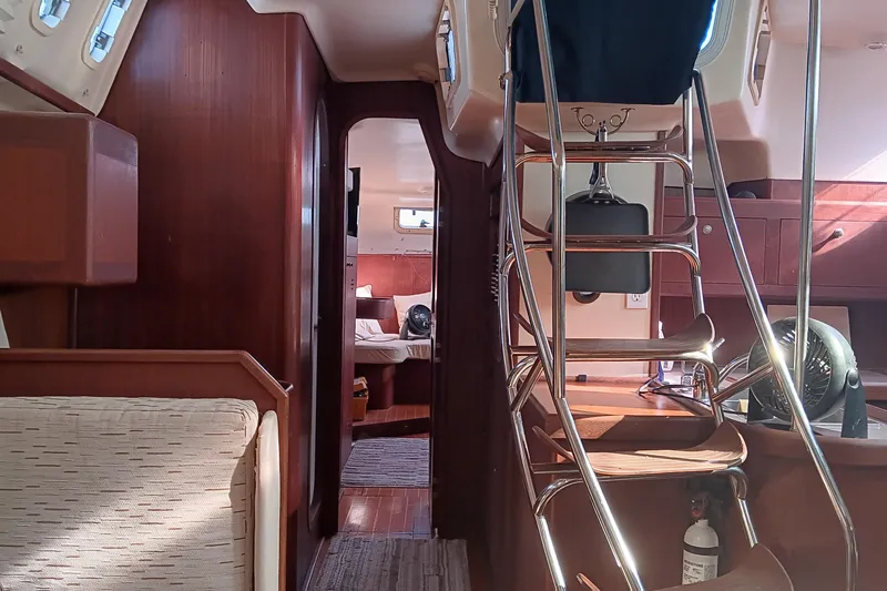 Heart Of Gold Yacht Photos Pics Interior of a 1998 Hunter 450 sailboat, featuring wooden cabinetry and a cozy cabin space.