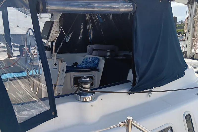 Heart Of Gold Yacht Photos Pics Cockpit of a 1998 Hunter 450 sailboat with blue canvas cover and steering wheel.