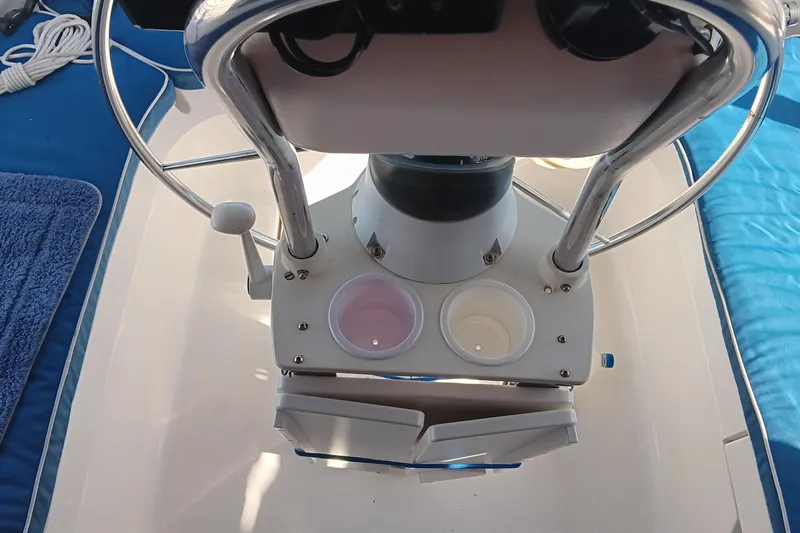 Heart Of Gold Yacht Photos Pics Steering wheel and console of a 1998 Hunter 450 yacht, featuring cup holders and navigation equipment.