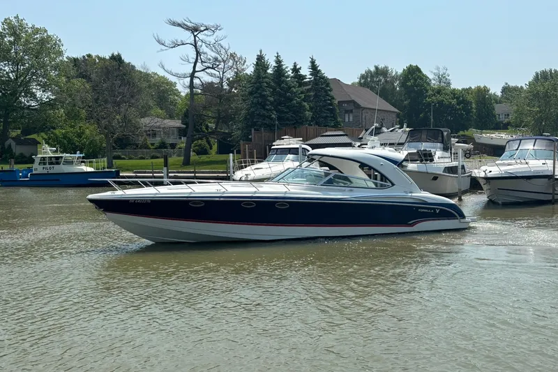  Yacht Photos Pics 2007 Formula 400 Super Sport boat cruising on a calm river near a marina.