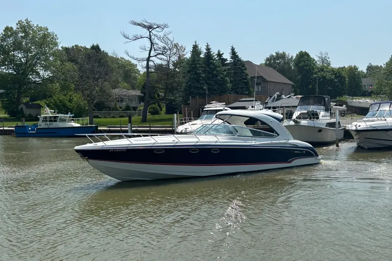  Yacht Photos Pics 2007 Formula 400 Super Sport boat cruising on a calm river near a marina.