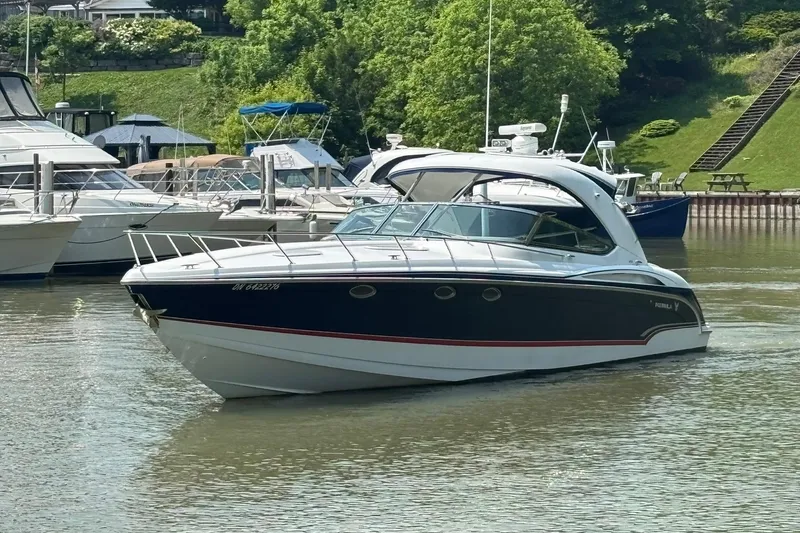  Yacht Photos Pics 2007 Formula 400 Super Sport boat docked in a marina, surrounded by lush greenery.