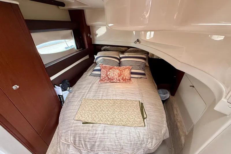  Yacht Photos Pics Cozy bedroom interior of 2014 Meridian 391 Sedan yacht with striped pillows and wooden accents.