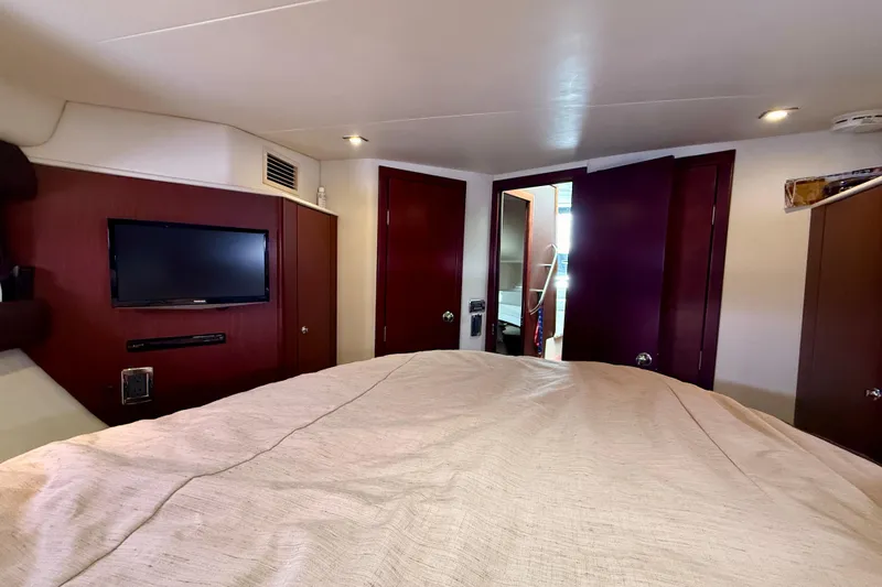  Yacht Photos Pics Interior of 2014 Meridian 391 Sedan yacht bedroom with TV and wooden cabinetry.