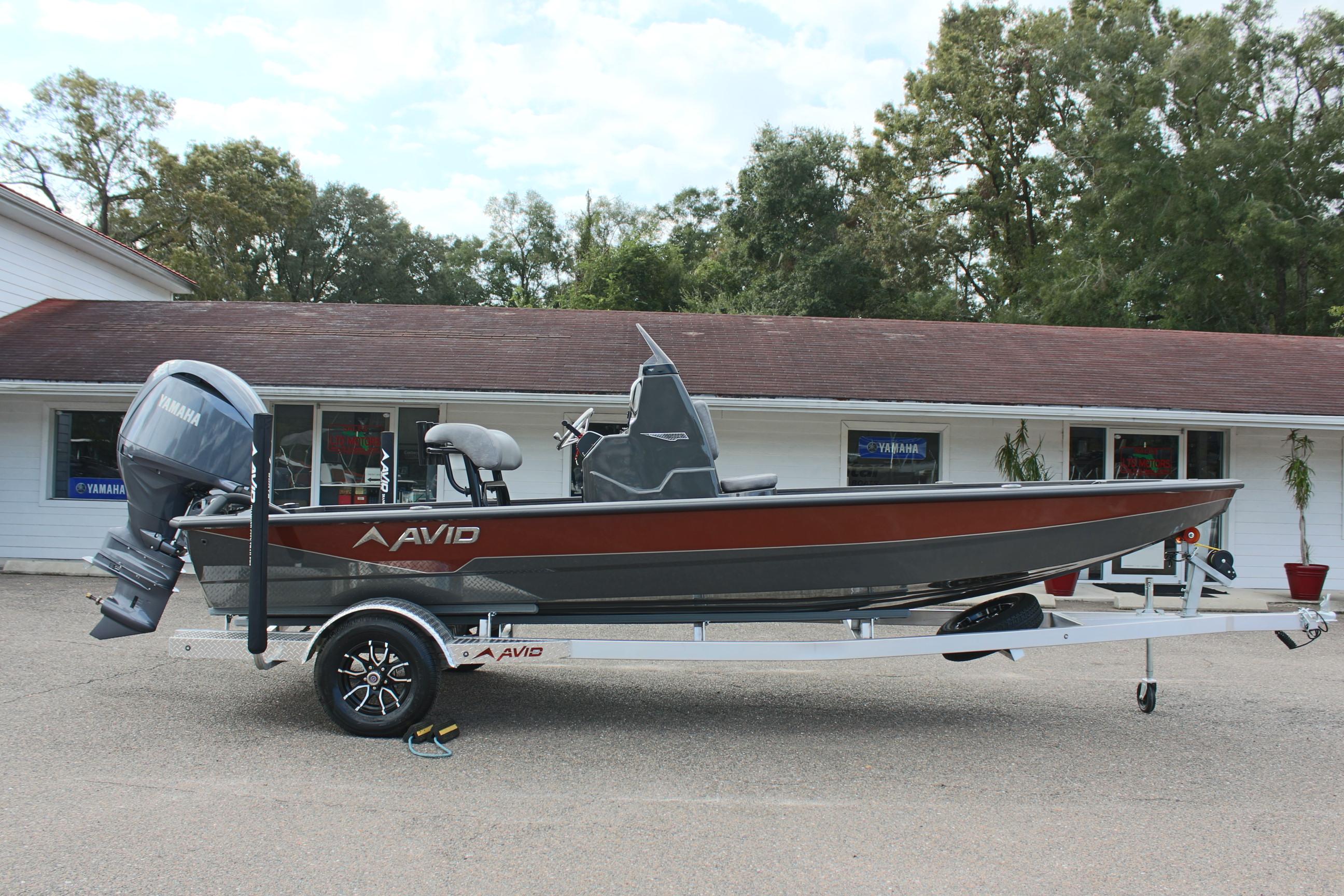 2025 Avid 21 FSX boat on trailer, parked outside a building.