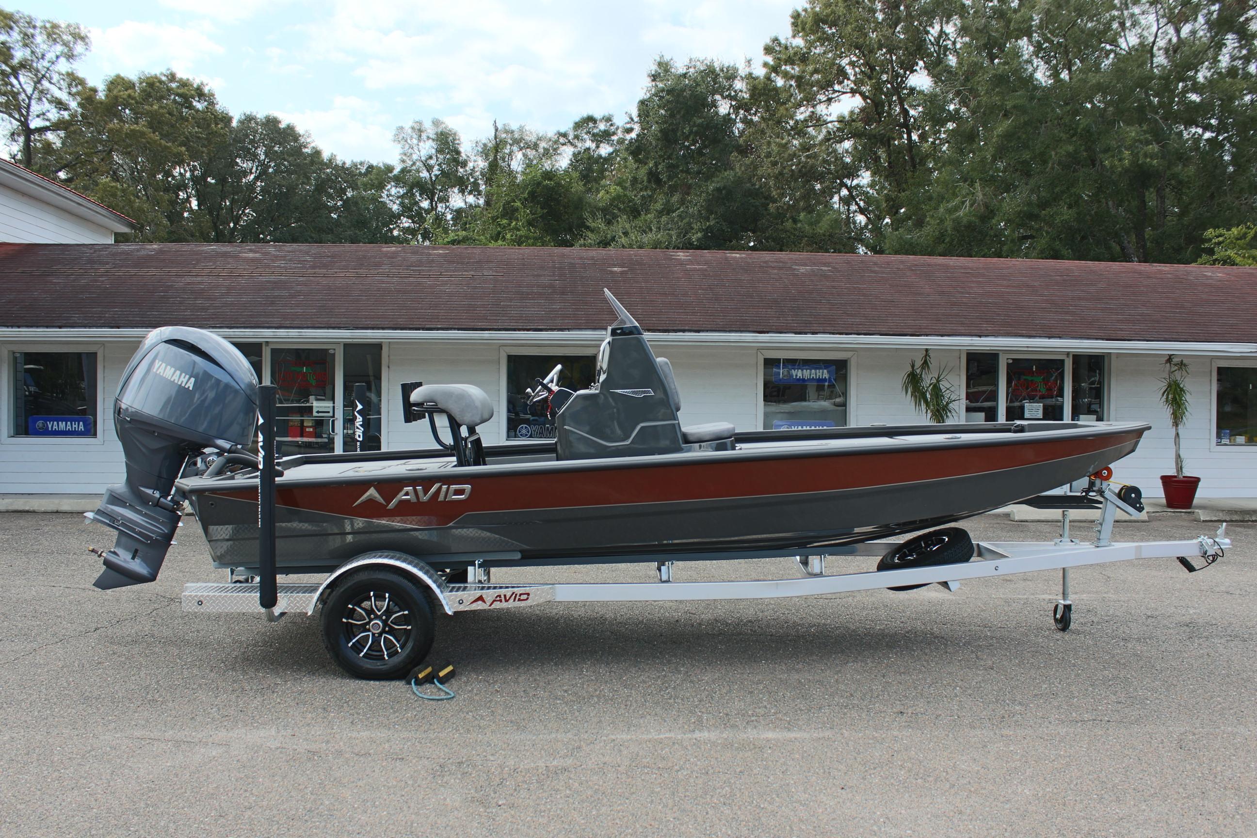 2025 Avid 21 FSX boat on trailer, parked outside a building.