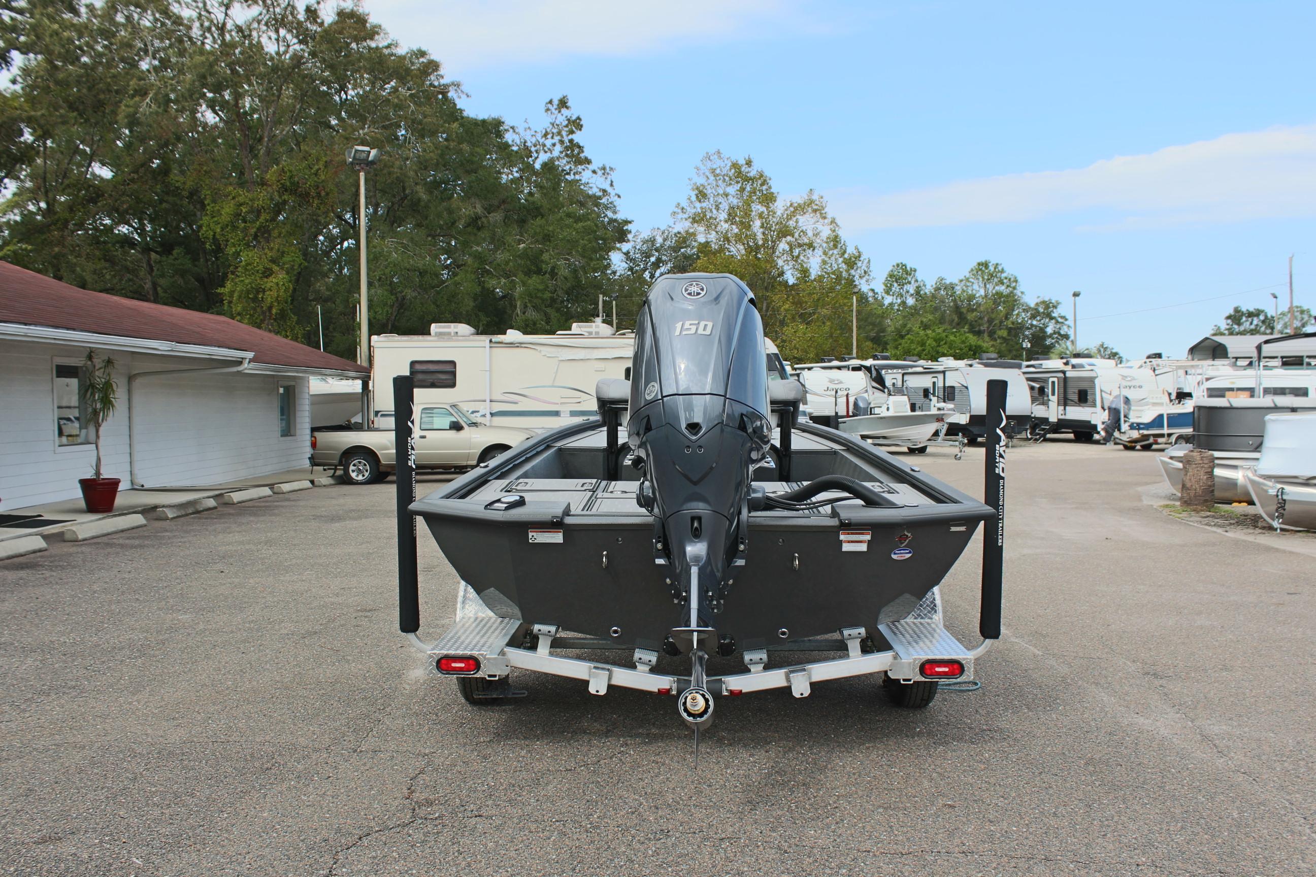 2025 Avid 21 FSX boat on trailer, parked in lot with RVs and trees.