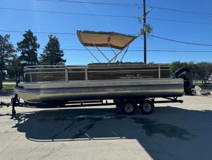 2025 Sun Tracker 24 Sportfish XP3 pontoon boat on trailer, parked outdoors.