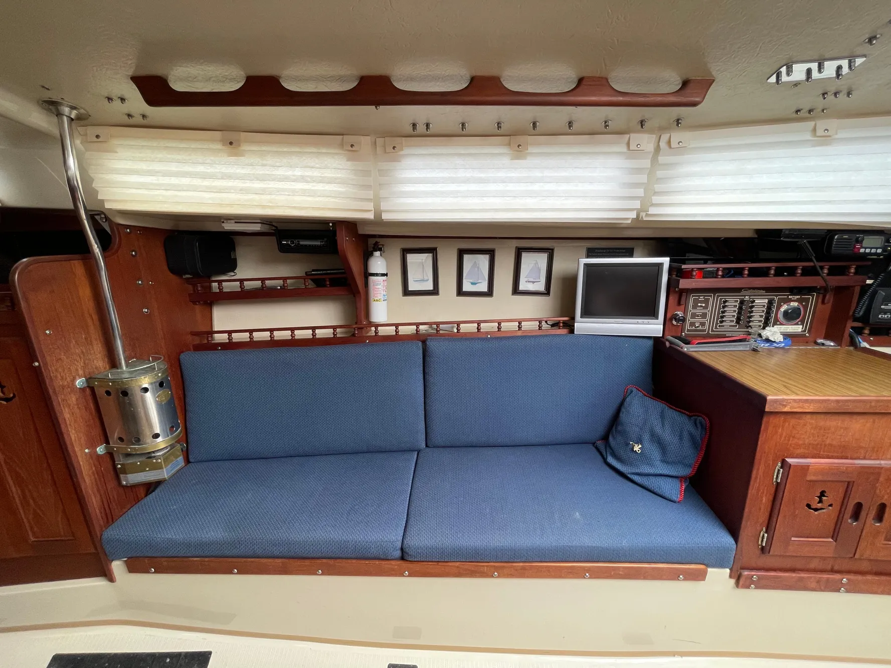 Interior of 1984 Catalina 30 sailboat with blue cushioned seating and wooden cabinetry.