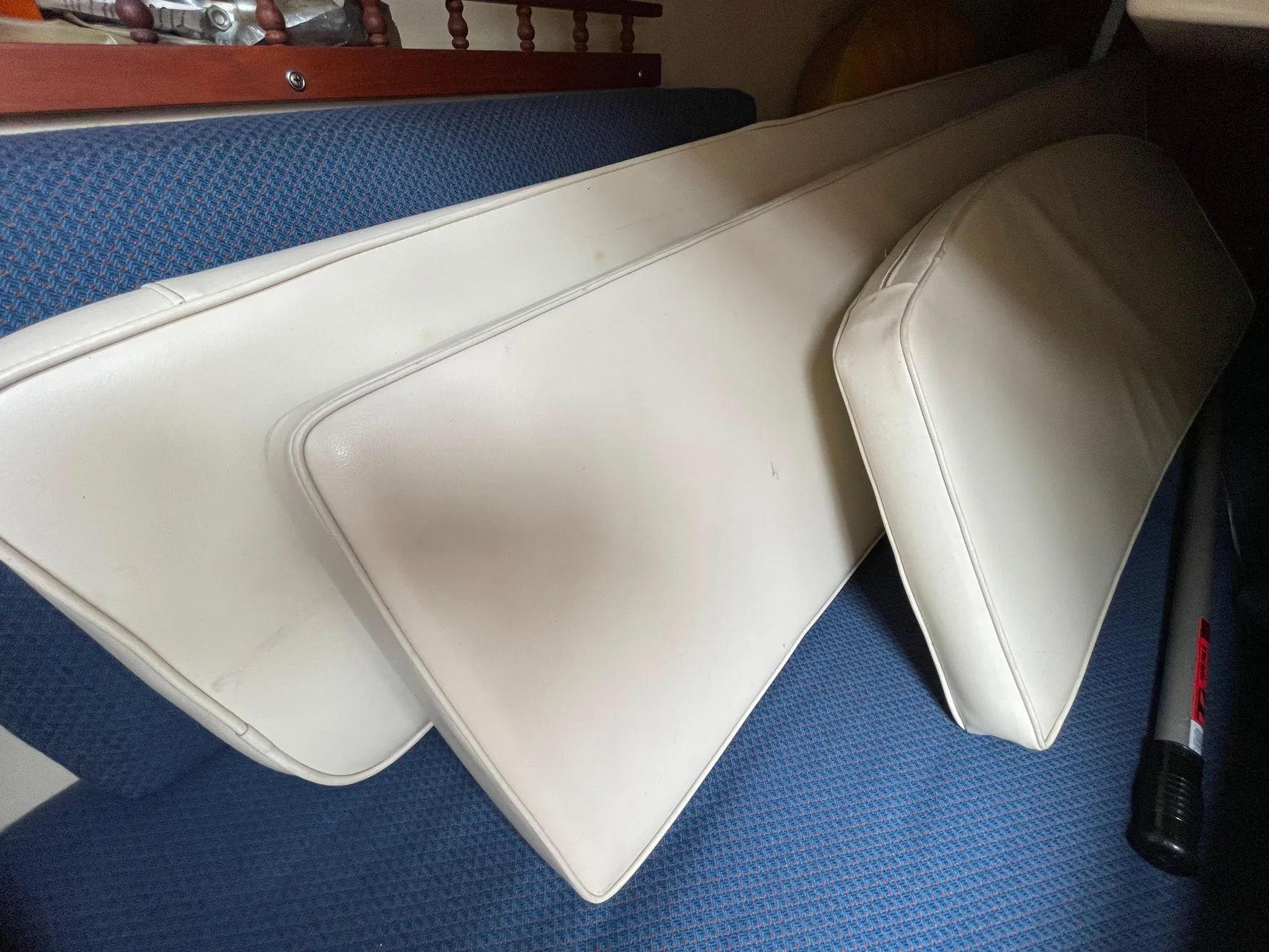 Cushions from a 1984 Catalina 30 sailboat, placed on a blue fabric surface.