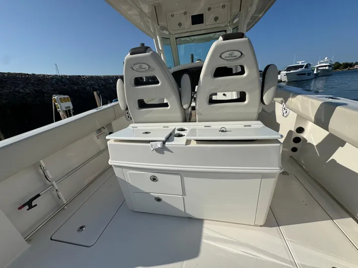  Yacht Photos Pics 2023 Sailfish 312 CC boat interior with dual seats and storage, docked by the water.