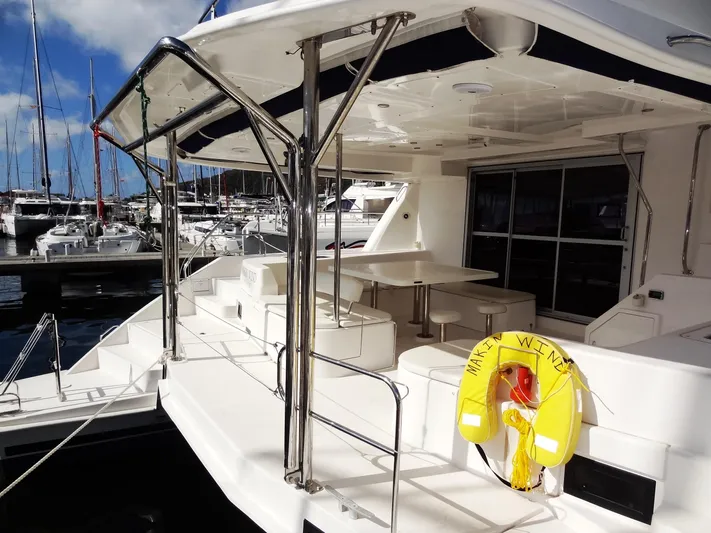 Makin Wind Yacht Photos Pics 2017 Leopard 51 Powercat yacht docked at marina, featuring spacious deck and seating area.