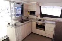 Modern kitchen interior of 2017 Leopard 51 Powercat yacht with light wood cabinetry.