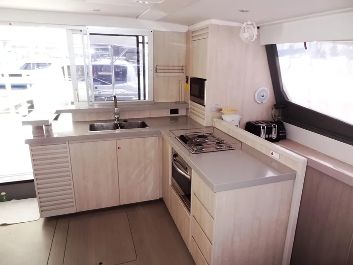 Makin Wind Yacht Photos Pics Modern kitchen interior of 2017 Leopard 51 Powercat yacht with light wood cabinetry.