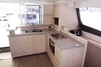 Modern kitchen interior of 2017 Leopard 51 Powercat yacht with light wood cabinetry.