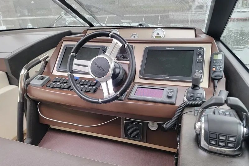 Yacht Photos Pics Control panel of a 2013 Prestige 500 S yacht with steering wheel and navigation equipment.