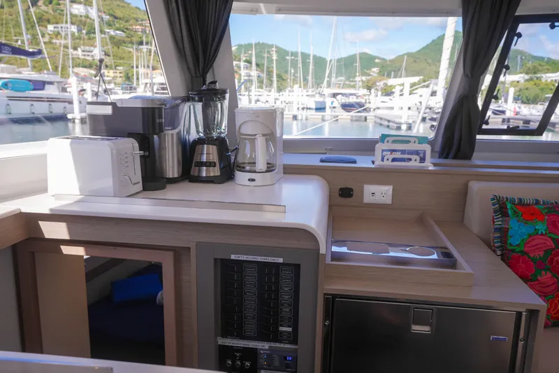 Firefly Yacht Photos Pics Modern kitchen interior of 2023 Fountaine Pajot Isla 40 catamaran with appliances and marina view.