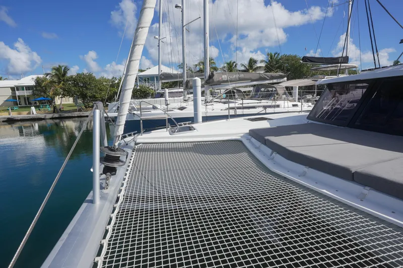 Firefly Yacht Photos Pics 2023 Fountaine Pajot Isla 40 catamaran docked, featuring spacious deck and netting.