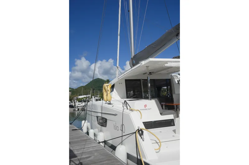 Firefly Yacht Photos Pics 2023 Fountaine Pajot Isla 40 catamaran docked at marina under clear blue sky.