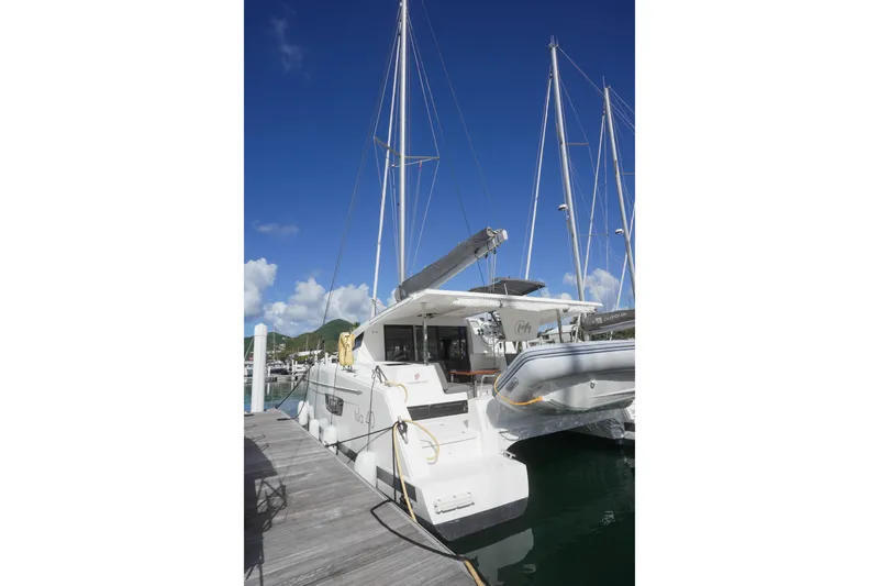 Firefly Yacht Photos Pics 2023 Fountaine Pajot Isla 40 catamaran docked at marina under clear blue sky.
