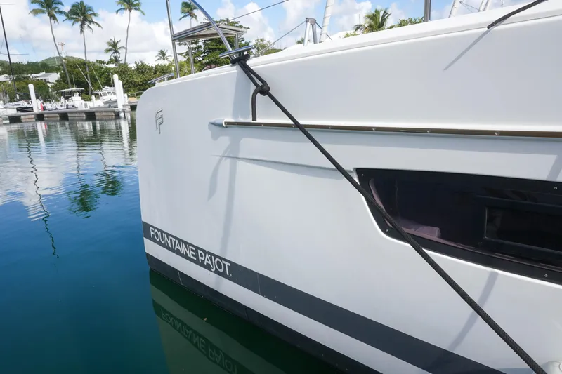 Firefly Yacht Photos Pics 2023 Fountaine Pajot Isla 40 catamaran docked in a serene marina setting.