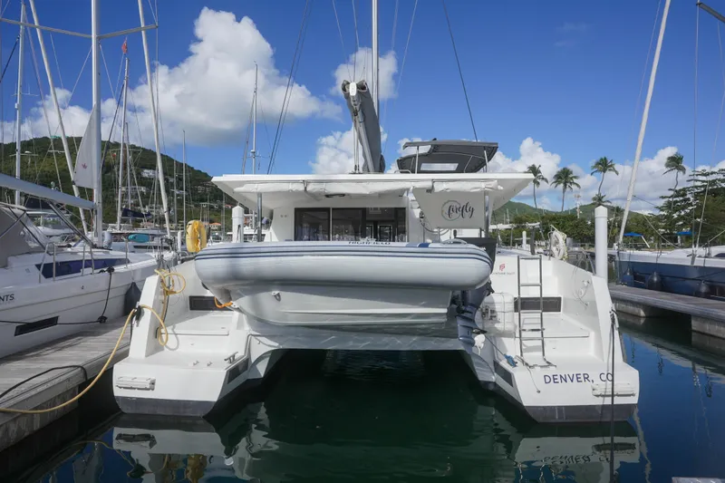 Firefly Yacht Photos Pics 2023 Fountaine Pajot Isla 40 catamaran docked at marina under blue sky.