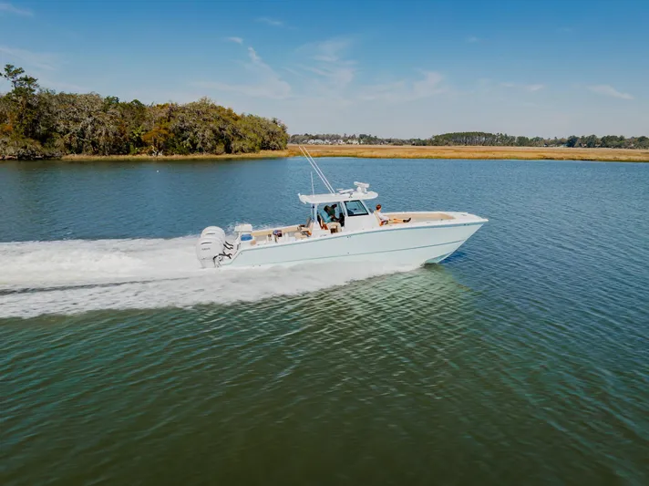  Yacht Photos Pics Freeman 38 boat cruising on a serene lake, 2025 model, under clear blue skies.