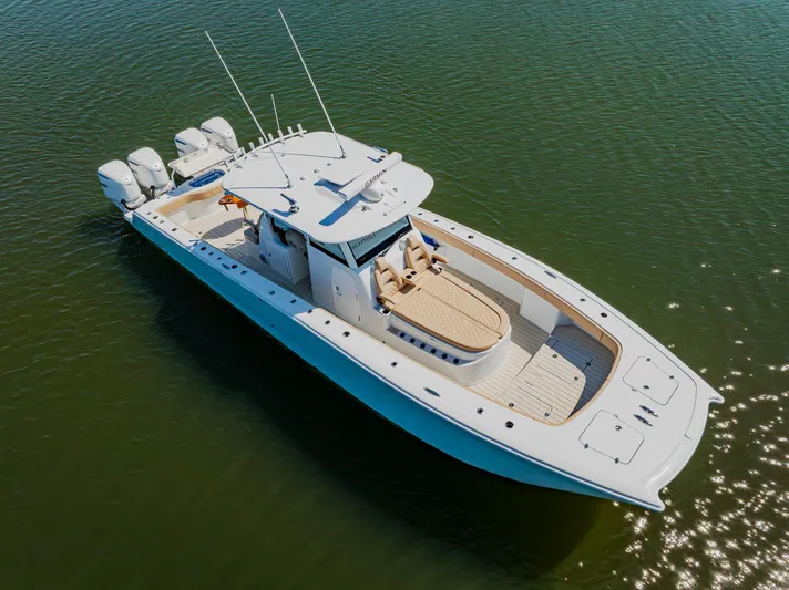  Yacht Photos Pics 2025 Freeman 38 boat on calm water, featuring sleek design and multiple outboard engines.