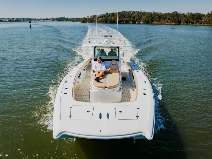  Yacht Photos Pics 2025 Freeman 38 boat cruising on a calm river with passengers onboard.