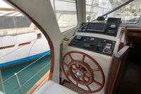 Helm of a 1991 Custom 23m Epoxy Hull boat with wooden steering wheel.