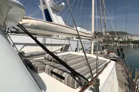Sailing yacht with striped cushions, Custom 23m Epoxy Hull, docked in a marina, 1991 model.