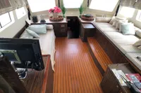 Luxurious interior of a 1991 Custom 23m Epoxy Hull yacht with elegant wood flooring.