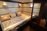 Luxurious bedroom in a 1991 Custom 23m Epoxy Hull yacht with elegant decor.