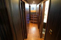 Luxurious yacht interior hallway with wooden flooring and ambient lighting, Custom 23m Epoxy Hull, 1991.