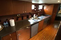Luxurious yacht kitchen with wooden cabinets, stainless steel appliances, and sleek countertops, 1991 Custom model.