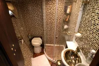 Luxurious yacht bathroom with mosaic tiles, glass shower, and gold fixtures, 1991 Custom 23m Epoxy Hull.