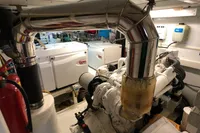 Engine room of a 1991 Custom 23m Epoxy Hull boat with visible machinery and exhaust system.