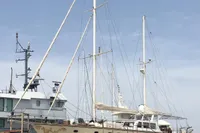 Sailboat with dual masts, Custom 23m Epoxy Hull, 1991, docked for maintenance.