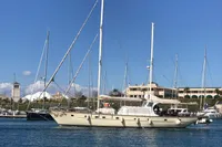 Sailing yacht with custom 23m epoxy hull, 1991, docked in a marina under clear skies.